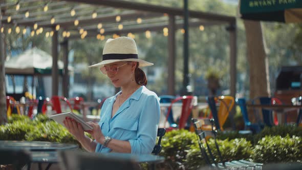 Smiling tourist with a memory book in a cafe