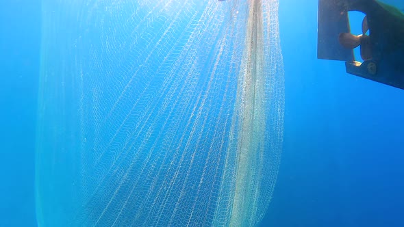 Fishing Net Hanging From Boat Under Sea in Underwater