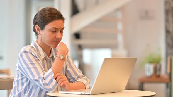 Pensive Young Indian Woman Thinking and Working on Laptop in Cafe 