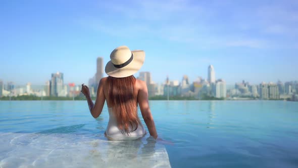 Young asian woman enjoy around outdoor swimming pool for leisure