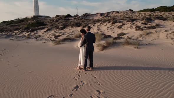 Loving bride and groom enjoying romantic moment on sandy shore