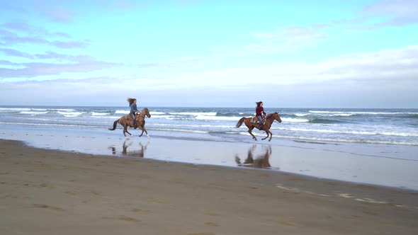 Women riding horses at beach