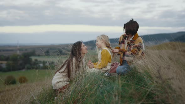 Two Loving Lesbians Playing with Pretty Daughter in Grass