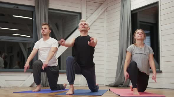 Group of People Doing Yoga in the Hall