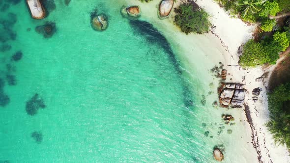 Aerial drone shot landscape of beautiful coastline beach break by blue water and white sand backgrou