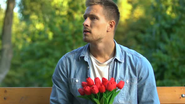 Nervous Man With Bunch of Tulips Sitting on Bench Waiting for Girlfriend, Date