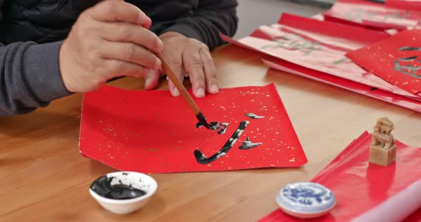 Man write chinese calligraphy for lunar new year