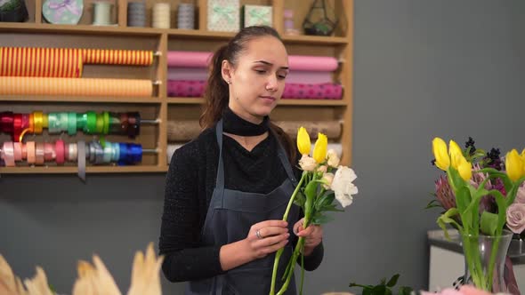 Slowmotion Shot of Young Female Florist Arranging Modern Bouquet at Flowers Shop