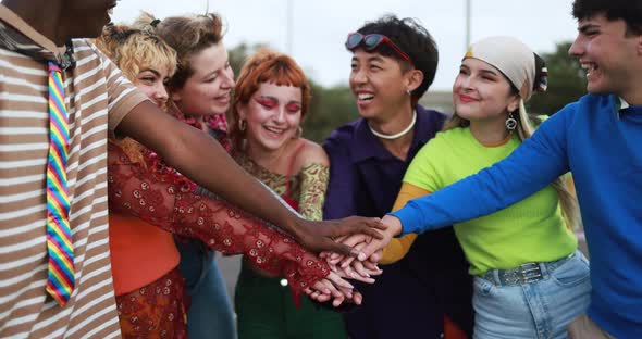 Young diverse people celebrating together stacking hands outdoor