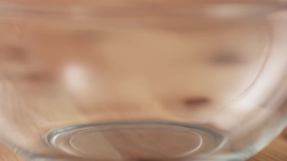 Camera follows putting bread crumb into a bowl. Slow Motion.