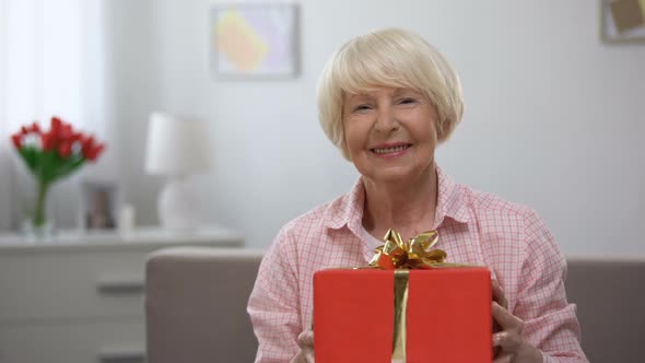 Happy Senior Woman Showing Gift Box at Camera, Birthday Celebration, Present