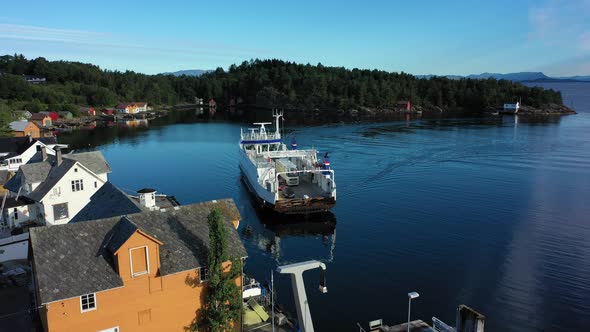 Battery powered car ferry Ytterøyningen is arriving Utbjoa in Norway during sunny summer day - Backw