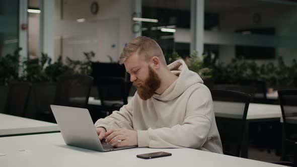 Bearded Guy Using Laptop Computer Working Sitting In Modern Office