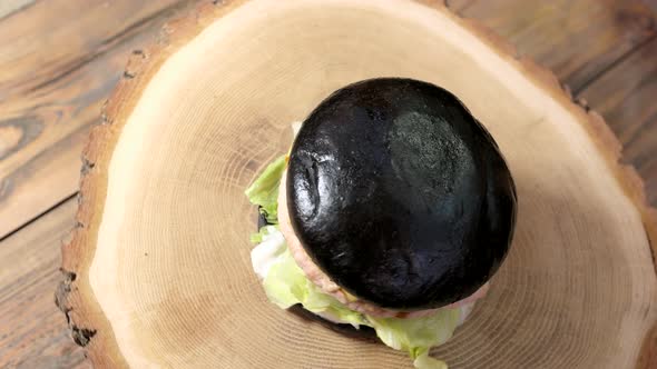 Black Burger on Wooden Background.