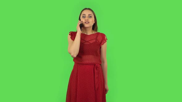 Tender Girl in Red Dress Is Talking for Mobile and Shocked Then Rejoice. Green Screen