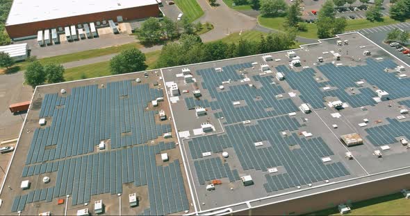 Panoramic aerial view on solar panels on factory roof absorb sunlight