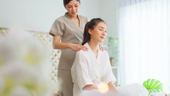 Asian young happy woman feeling relax during shoulder and back massage.