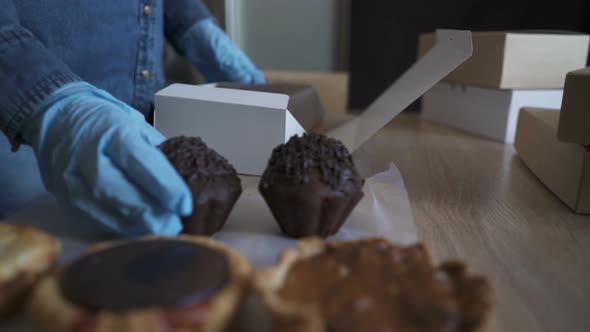 Homemade Pastry Delivery. Cake Shop Business. Woman Putting Cupcakes in Box.