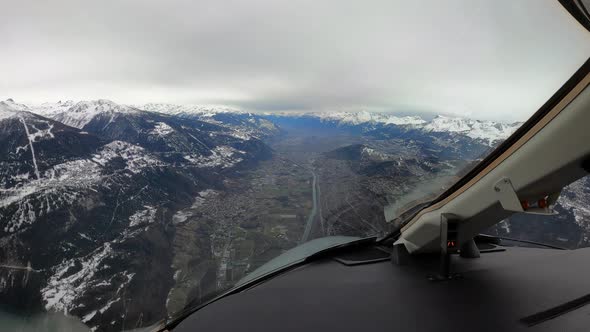 Airplane cockpit view of landing approach through Sion Valley mountains