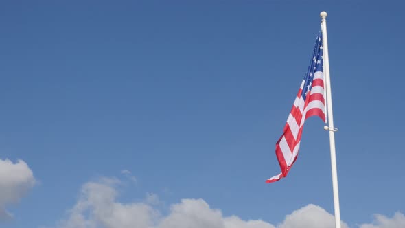 Fabric of American flag against blue sky waving 4K 2160p 30fps UltraHD video - Famous flag of United