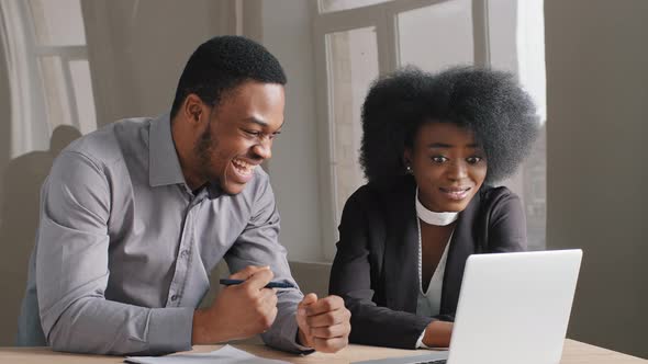 Young African American Office Workers Guy and Girl Work Successfully Together with Concentration