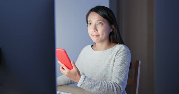 Woman work on computer and cellphone at night