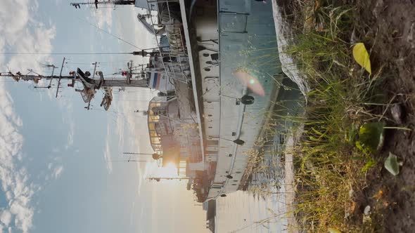 Vertical Video of the Old Fishery Vessel Standing at the Coast Through a Grass at Sunrise Sun Path