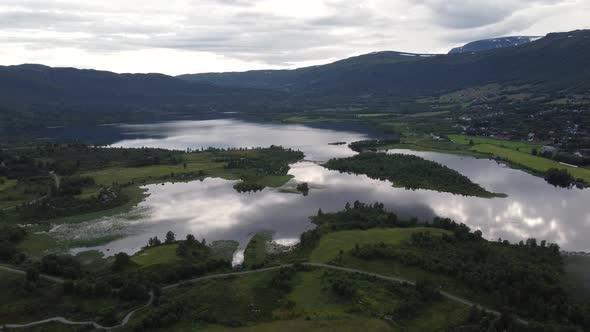 Popular Ustedalsfjorden lake at Geilo - Backward moving aerial at dawn with sky reflections in water