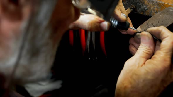 Senior goldsmith manufacturing bangle in workshop 4k