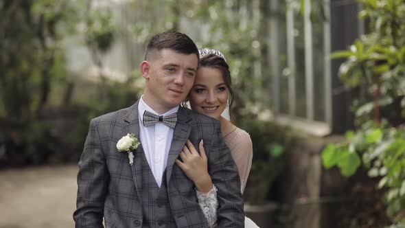 Newlyweds. Caucasian Groom with Bride Walking, Embracing, Hugs in Park. Wedding Couple