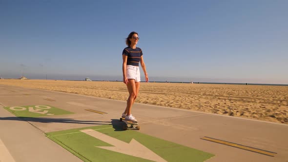 Young Woman With Skateboard In A Sunny Summer Day - slow motion