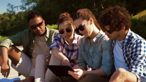 Friends with Tablet Pc on Wooden Terrace in Summer
