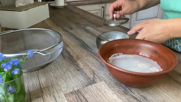 Woman Adding Sugar to Leaven at Home