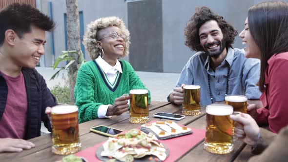 Group of Multiracial Friends Cheering with Beers in Terrace Bar