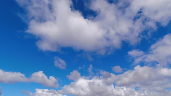 Timelapse: Abstract cumulus clouds cross natural empty blue sky