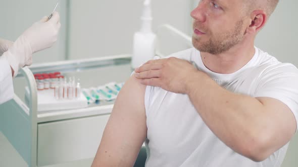 A Man is Getting Vaccinated in a Hospital Room