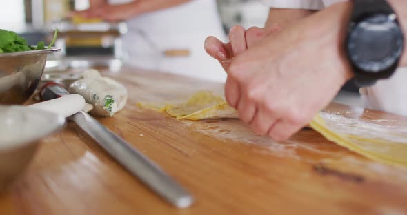 Caucasian female chef teaching diverse group preparing dishes and smiling