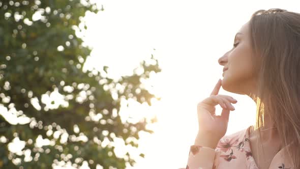 Woman with Loose Fair Hair in Pink Dress Smiles and Poses