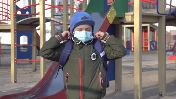 Caucasian Schoolboy in Face Mask Standing Alone on Children's Playground
