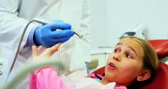 Girl stopping dentist for examining her in clinic