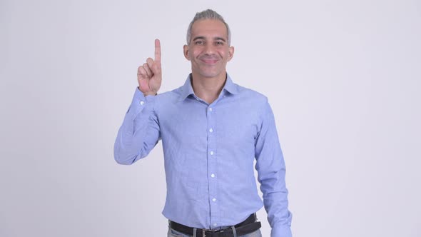 Happy Persian Businessman Pointing Up Against White Background