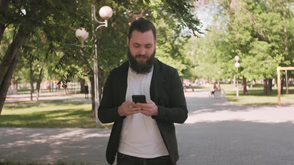 Man Walking Through Park and Chatting on Video Call