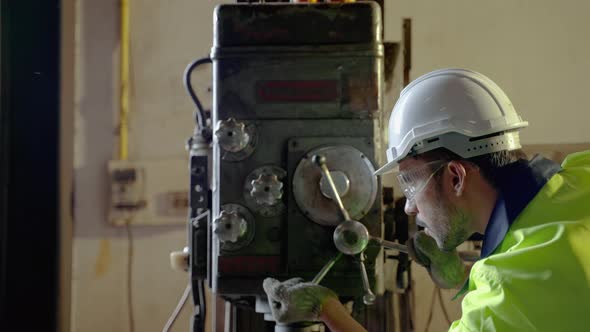 Caucasian workers use a lathe in an industrial factory. Working with labor-saving machines but still