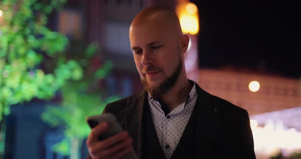 Businessman Using Smartphone at the Night City