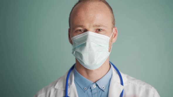 Pensive doctor put off protective face mask