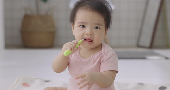 Adorable Asian Baby Practice To Using Toothbrush For Clean Her Oral For Good Oral Health.