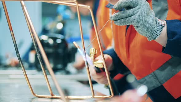 Metal Frames are Getting Welded By a Factory Worker