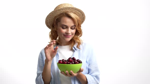 Smiling Woman Farmer in Straw Summer Hat Eating Fresh Cherry From Bowl Vitamin