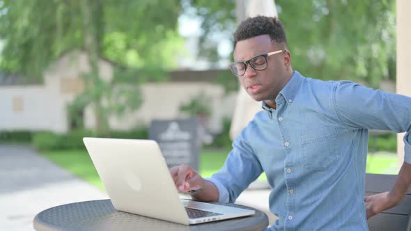 African Man with Laptop Having Back Pain