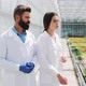 Two Researchers in Laboratory Robes Walk Around the Greenhouse. They Discuss the Success of Doing - VideoHive Item for Sale
